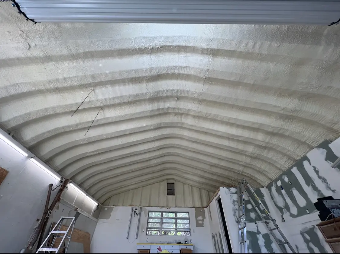 Spray polyurethane foam applied to the underside of a metal roof deck in Addison